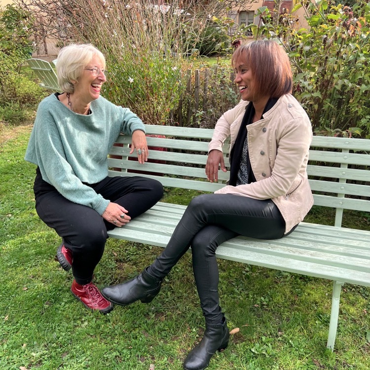 Deux femmes en discussion bienveillante lors d’un coaching personnel en extérieur