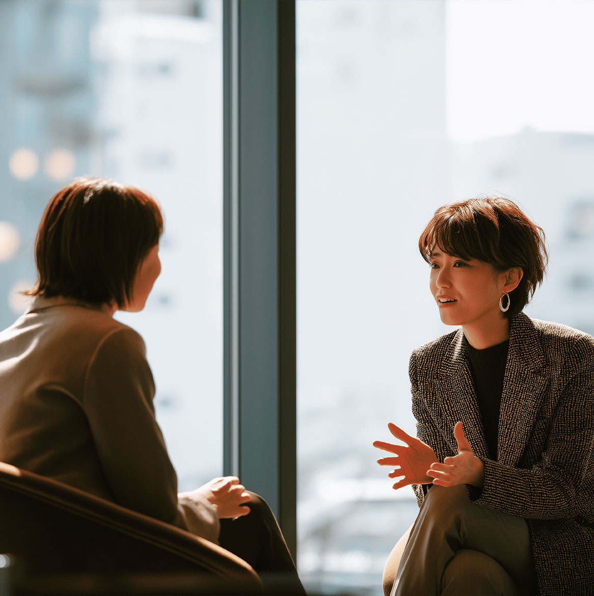 Deux personnes discutant en face à face dans un cadre professionnel, illustrant la communication et les réactions nerveuses lors d’un entretien d’embauche.