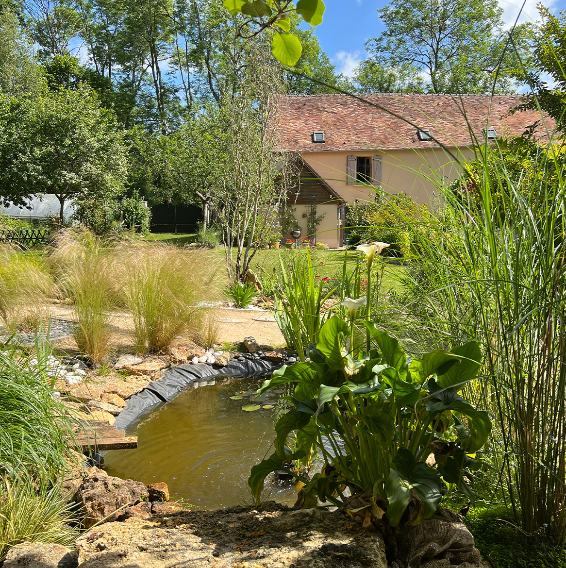 Jardin calme à Osélience avec bassin naturel, idéal pour une retraite silencieuse guidée.
