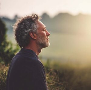 Homme assis en pleine nature, moment de pause et de ralentissement lors d’un séjour bien-être proche de Paris