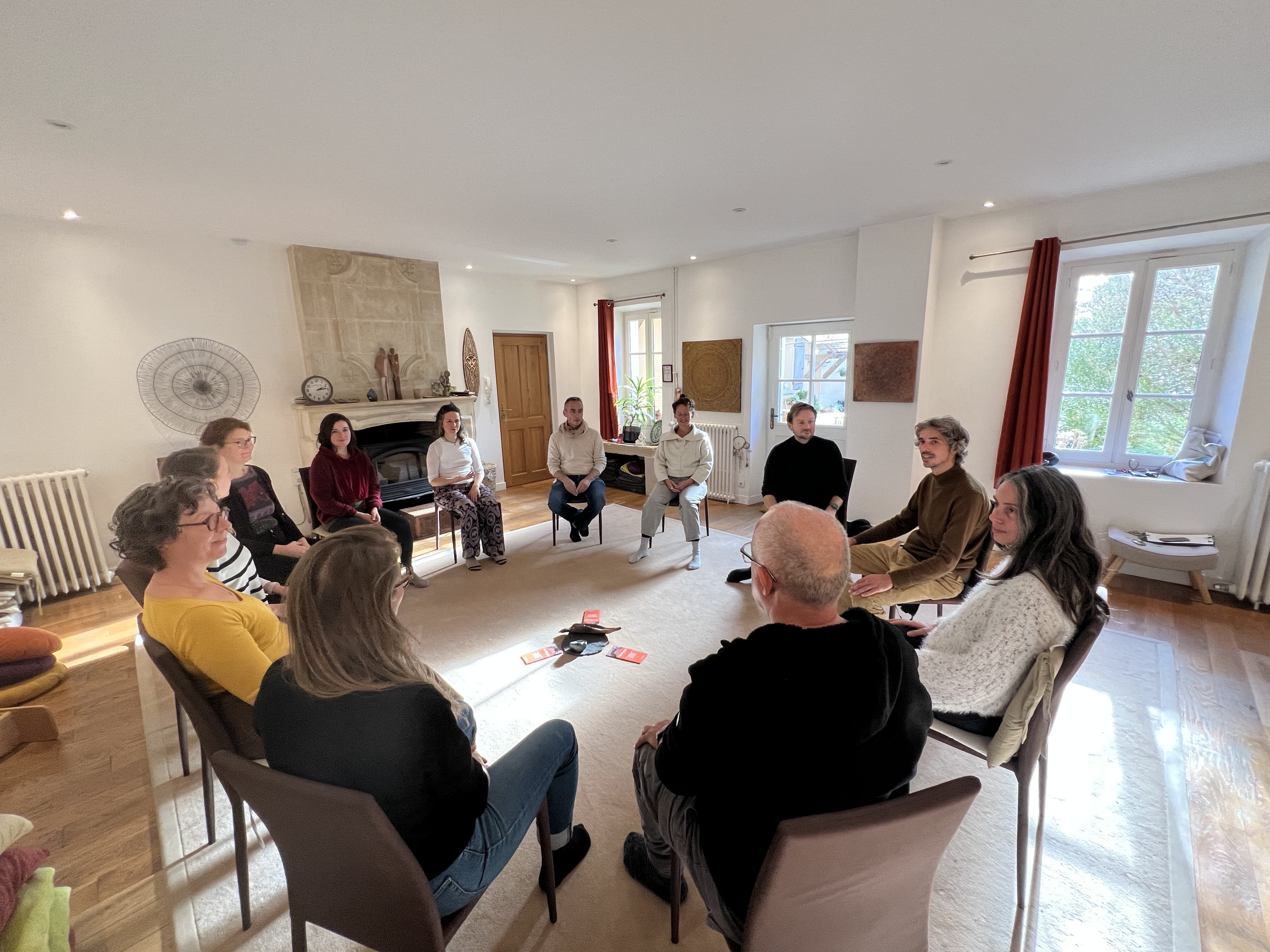Groupe en cercle lors d’un atelier Osélience dans une salle lumineuse, dédié au développement personnel et à l’intelligence collective.