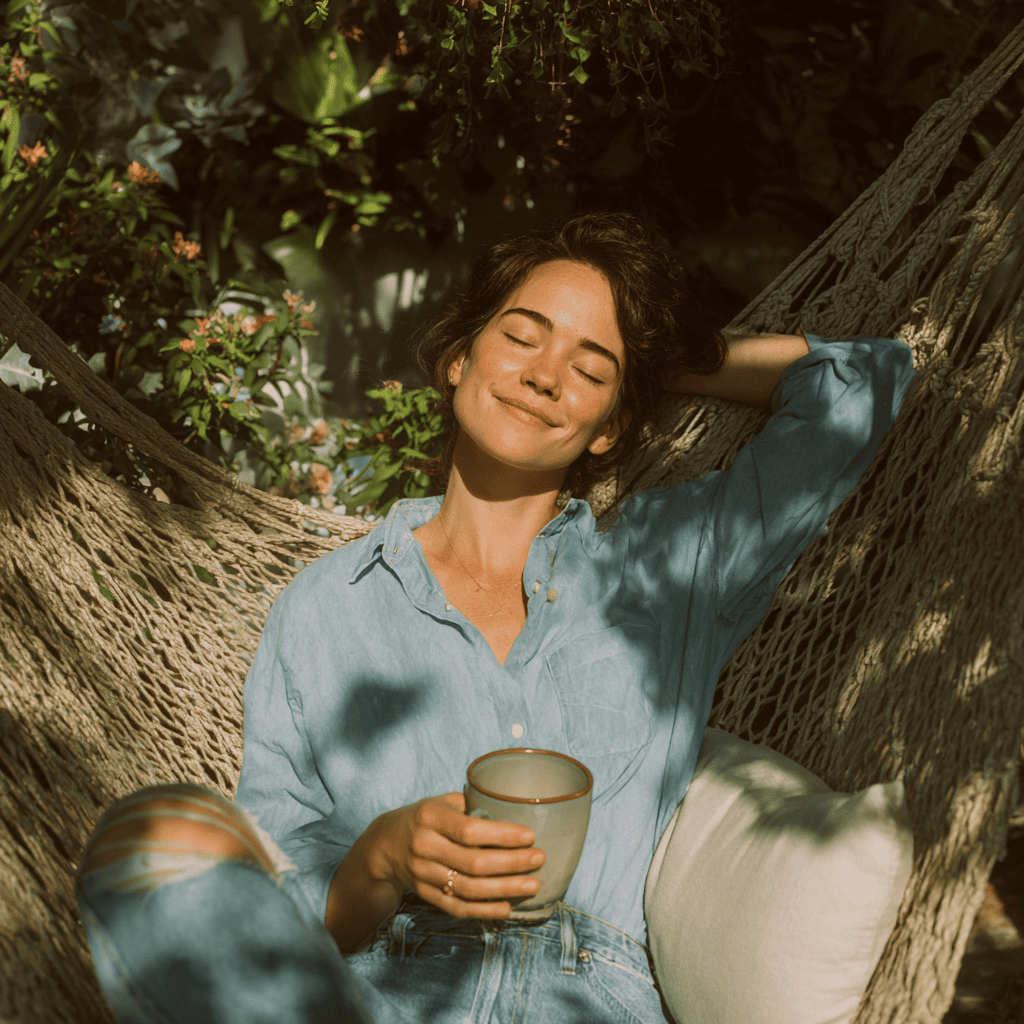 Femme détendue dans un hamac, savourant un moment de calme au soleil dans un cadre naturel, illustrant le bien-être d’une retraite silencieuse guidée.