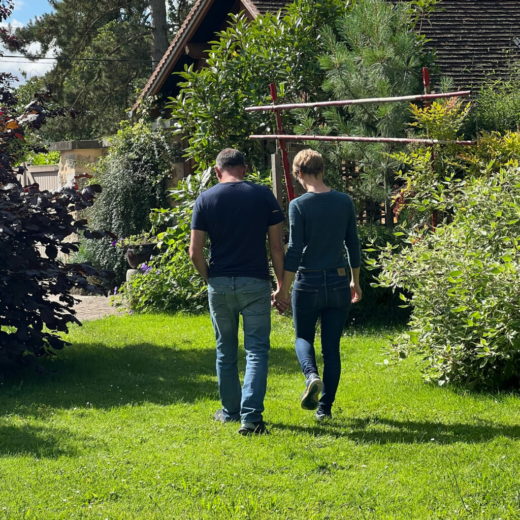Couple se promenant main dans la main dans le jardin lors d’un week-end Imago Osélience